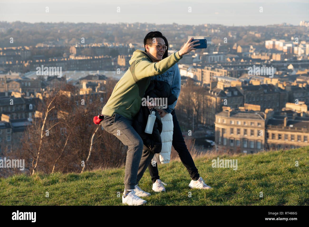 Edimburgo, Scozia, Regno Unito. Il 26 febbraio, 2019. Il turista a godere di vista di Leith da Calton Hill a Edimburgo dopo caldo giorno chiaro , Edimburgo, Scozia, Regno Unito Foto Stock