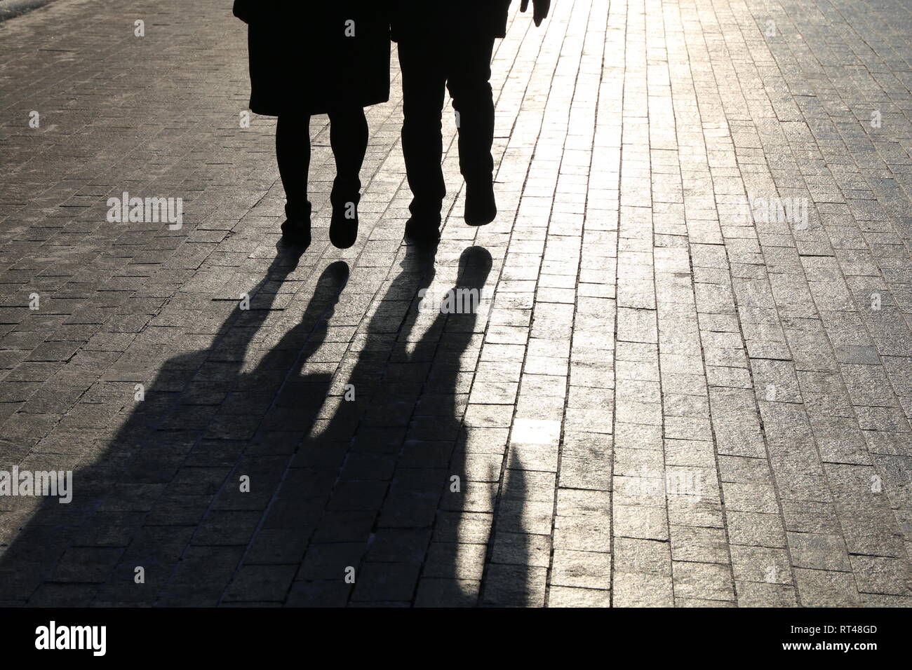 La gente che camminava per strada, le sagome di nero e le ombre sul marciapiede pedonale. Concetto di vita di città, i forestieri, storie drammatiche Foto Stock