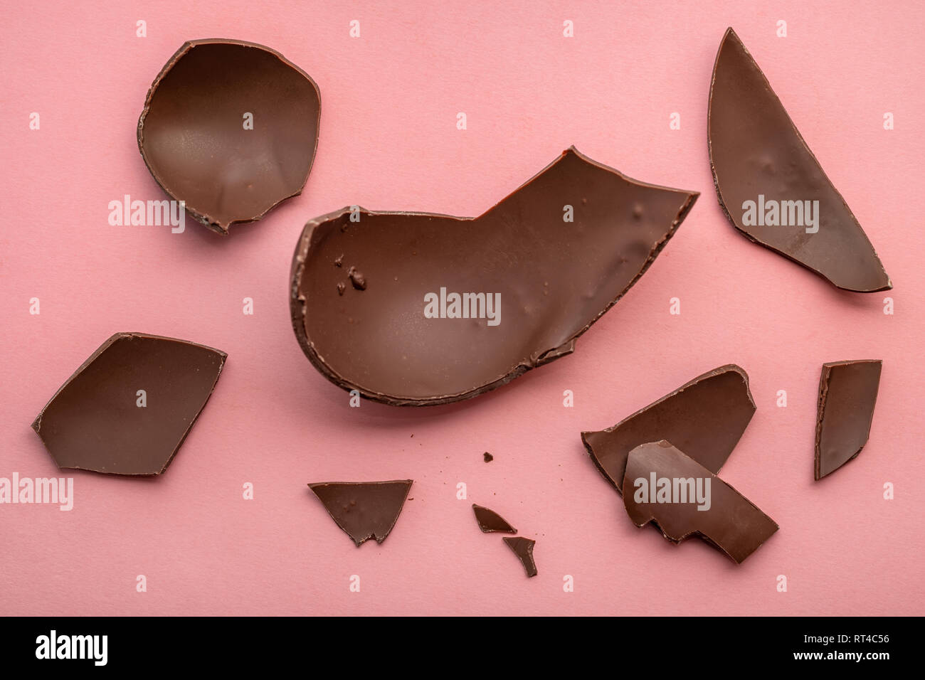 Rotture di cioccolato uovo di Pasqua su sfondo rosa, concetto di vacanza Foto Stock