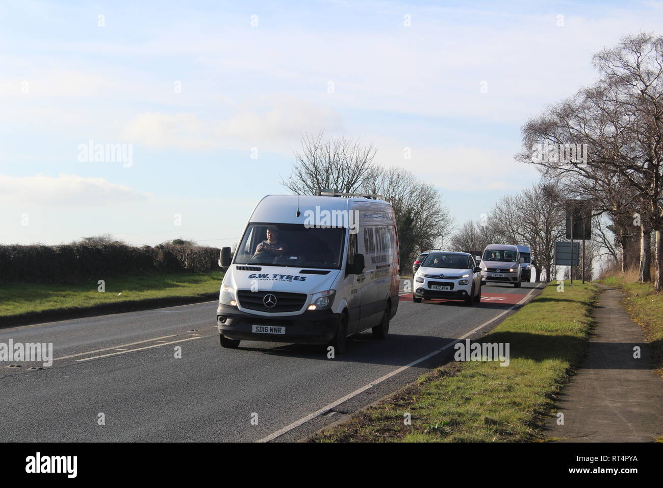 Strada di campagna con i furgoni e le vetture che viaggiano per lavoro e per piacere nello Yorkshire , Inghilterra Foto Stock
