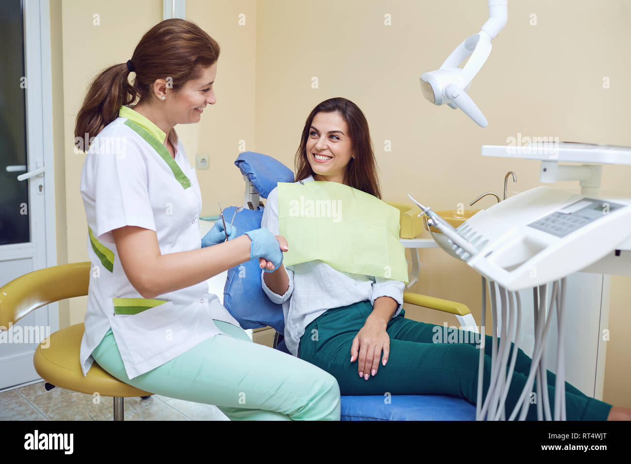 Dentista scuote le mani con una donna client in una clinica dentale Foto Stock