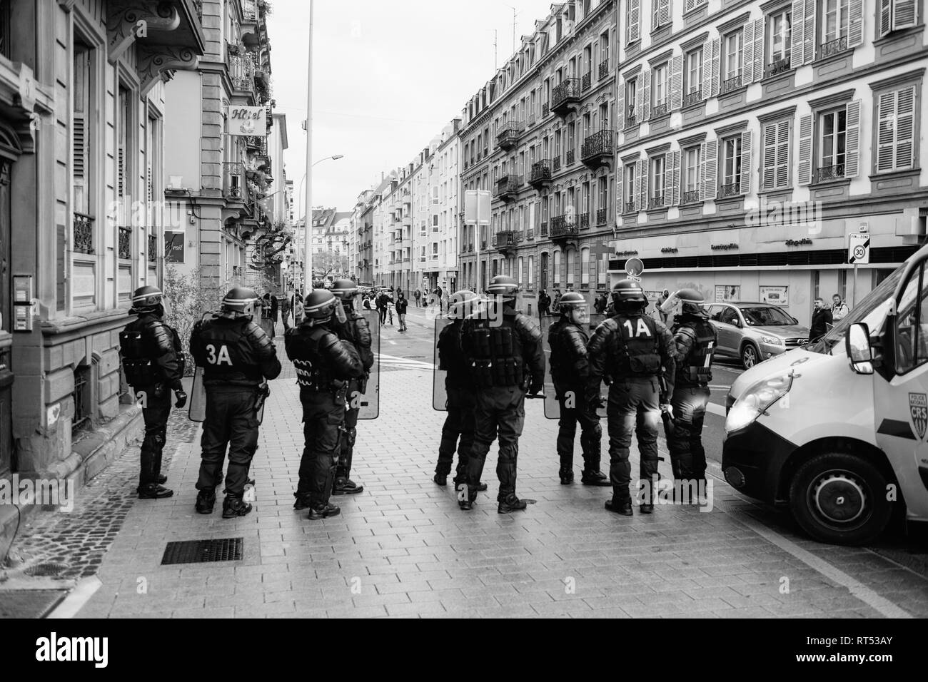 Strasburgo, Francia - 8 dicembre 2018: gli ufficiali di polizia che fissano la zona anteriore del Giallo giubbotti di manifestanti di movimento sul Quai des Bateliers street Foto Stock