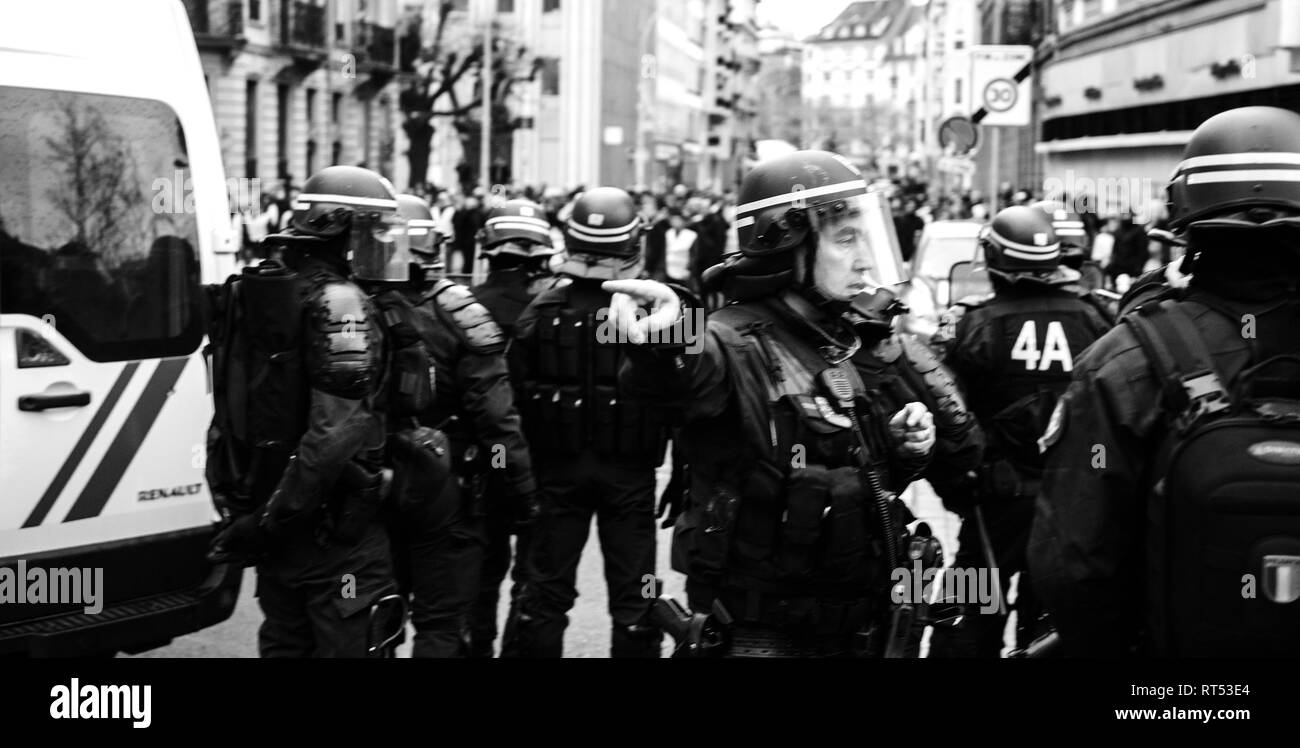 Strasburgo, Francia - 8 dicembre 2018: gli ufficiali di polizia che fissano la zona anteriore del Giallo giubbotti di manifestanti di movimento sul Quai des Bateliers street Foto Stock