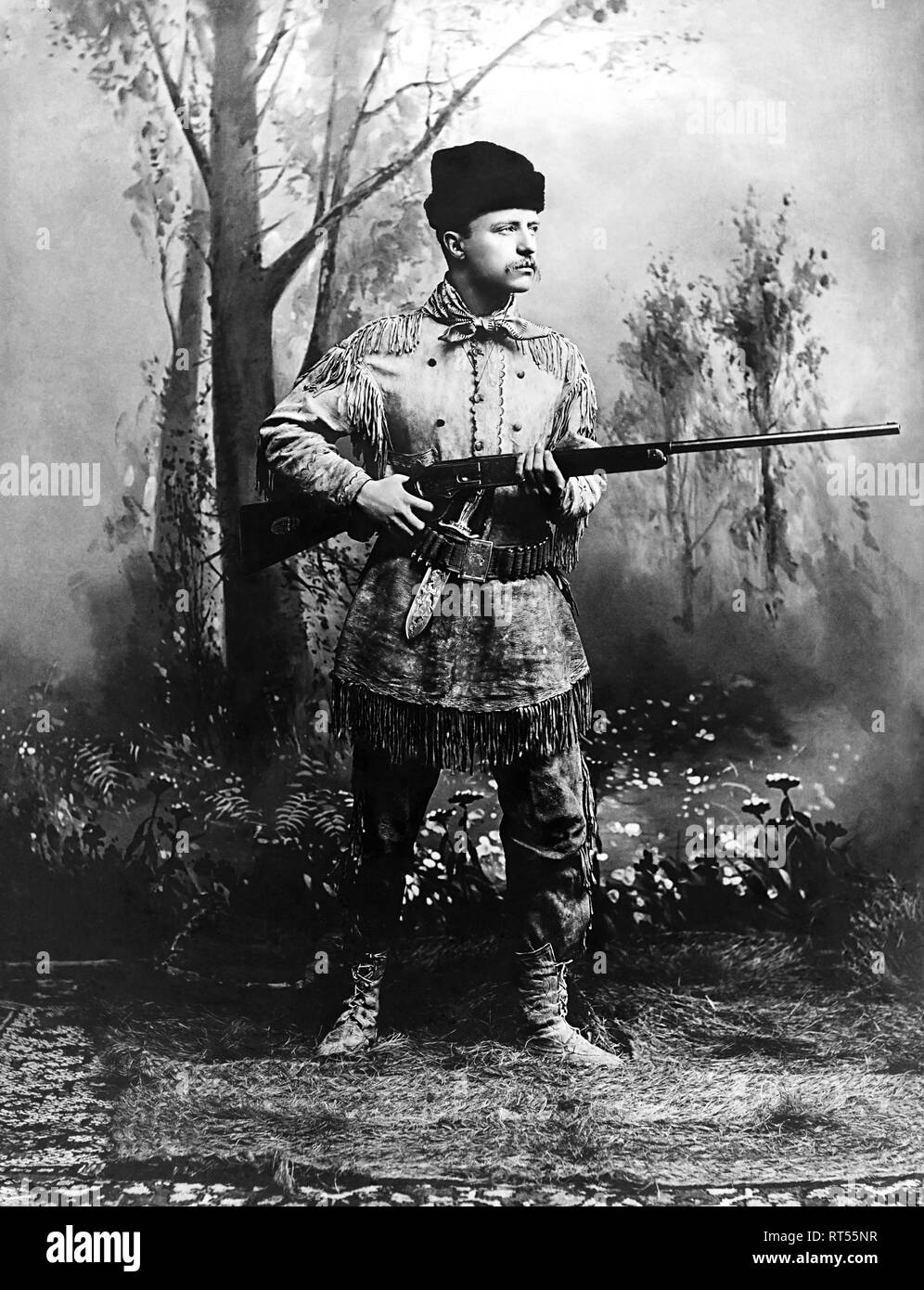 Theodore Roosevelt, tenendo in mano un fucile indossando un cervo pelle tuta di caccia nel 1885. Foto Stock