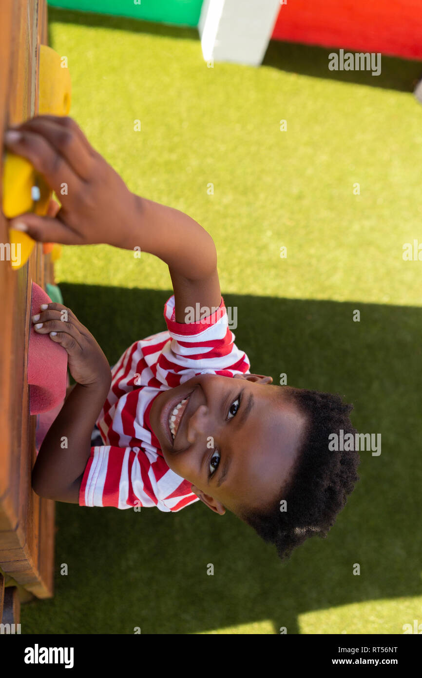 Scolaro salendo una parete nella scuola parco giochi Foto Stock