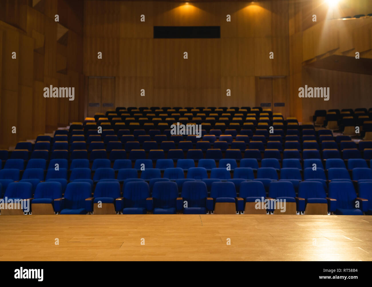 Auditorium con tutte le luci accese con sedia blu intorno Foto Stock
