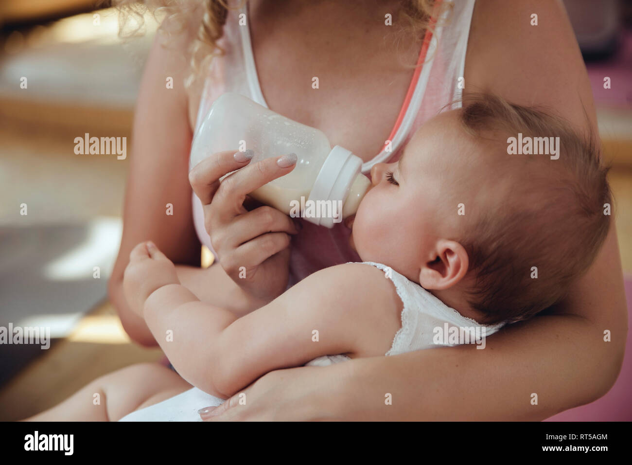 Bottiglia di madre-alimentando il suo bambino Foto Stock