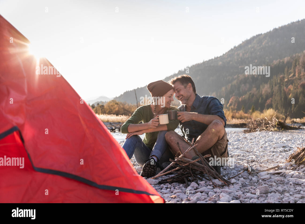 Coppia matura campeggio al Riverside nella luce della sera Foto Stock