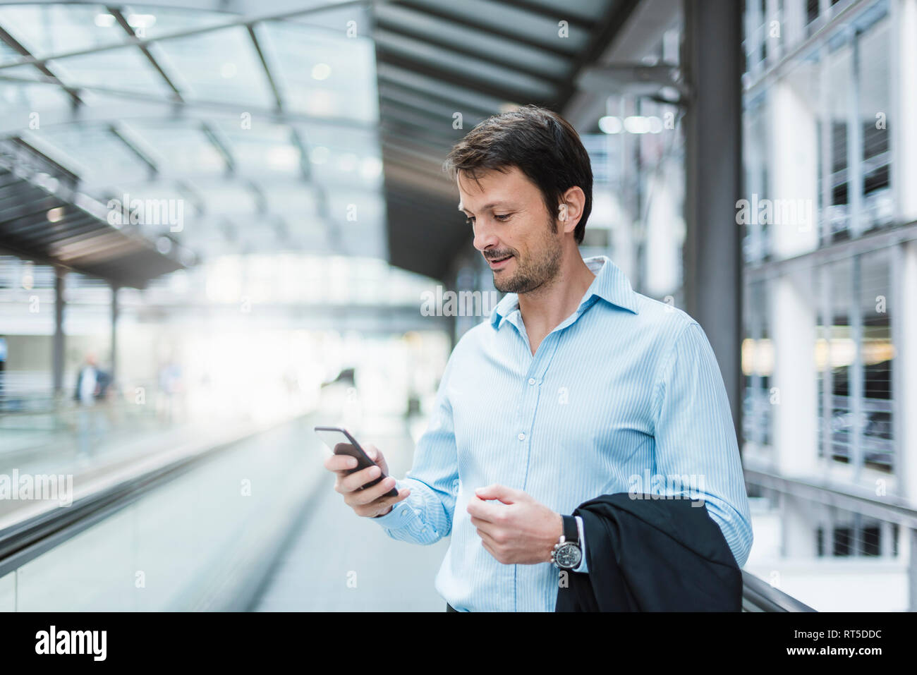 Imprenditore su un tapis roulant, utilizza lo smartphone Foto Stock