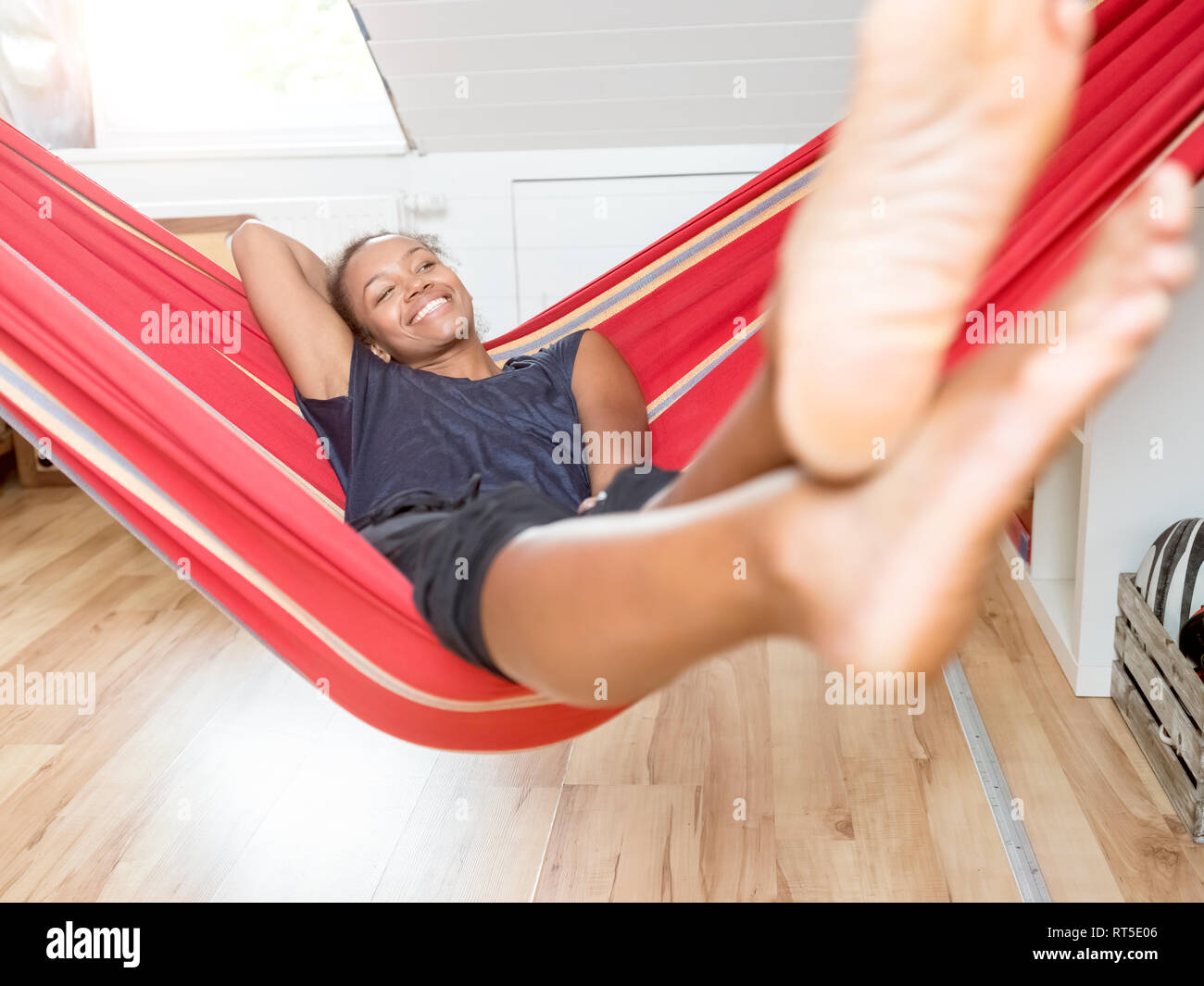 Sorridente giovane donna giacente in amaca Foto Stock