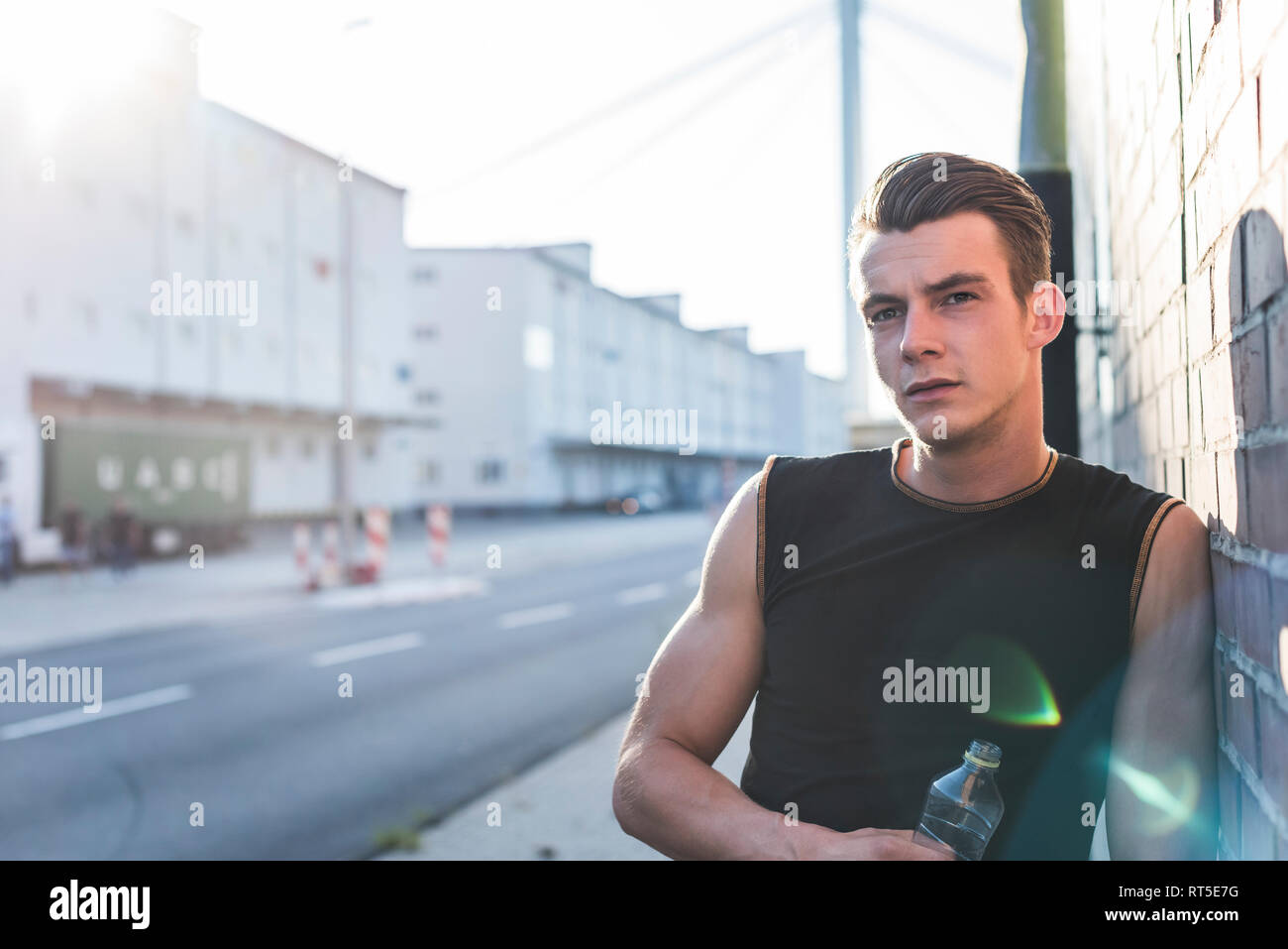 Germania, Mannheim, giovane atleta nella città con una bottiglia di acqua minerale, ritratto Foto Stock