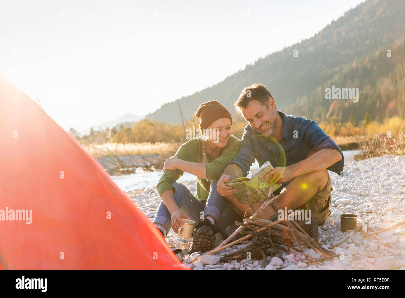 Coppia matura campeggio al Riverside, cerca sulla mappa Foto Stock