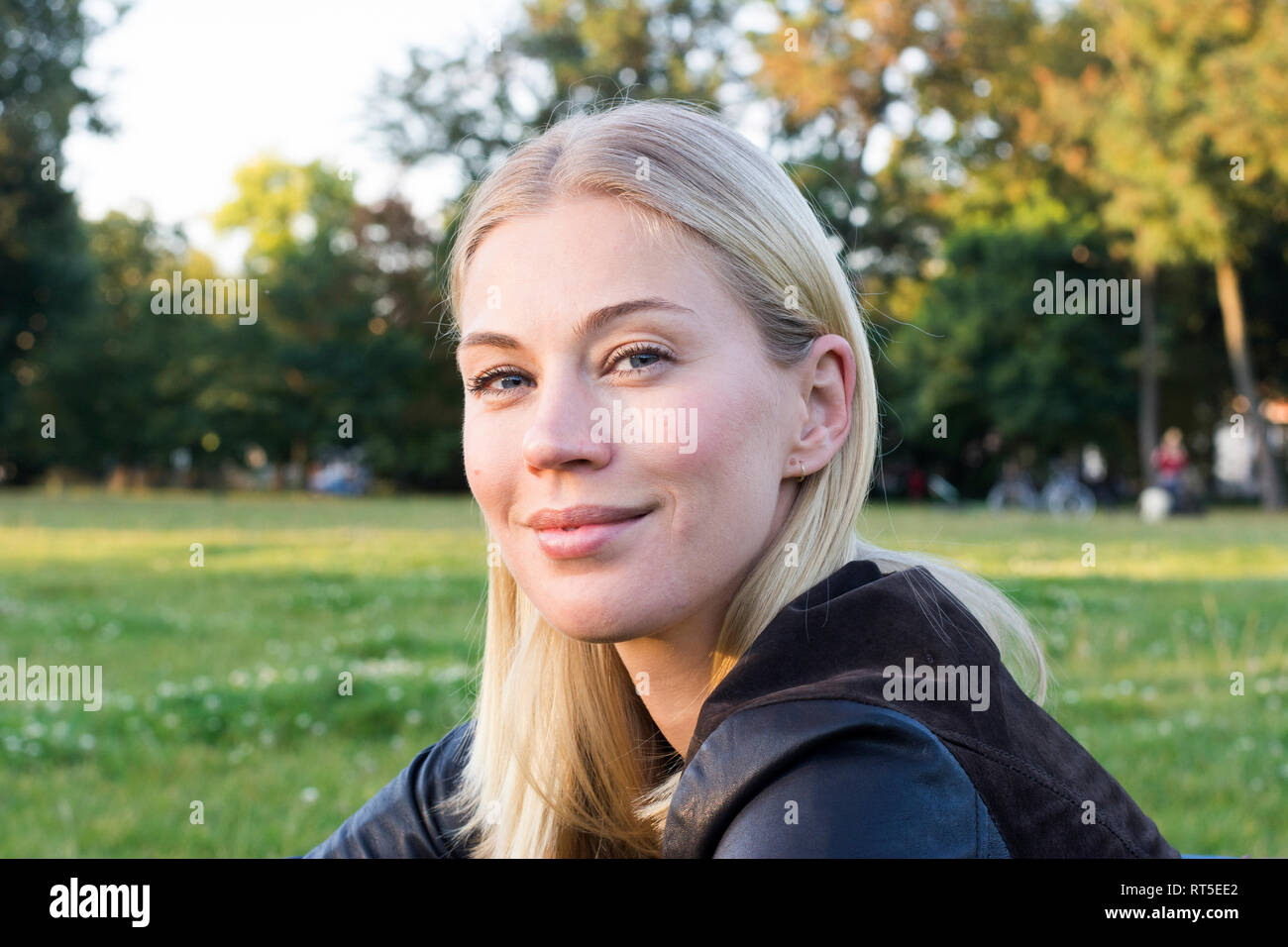 Ritratto di contenuto donna bionda rilassante in un parco Foto Stock
