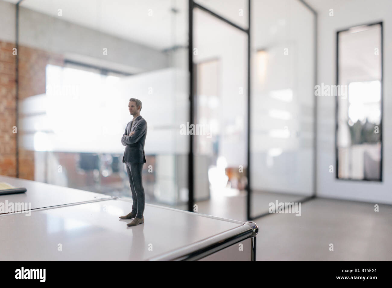 Imprenditore figurina in piedi sulla scrivania in ufficio moderno Foto Stock
