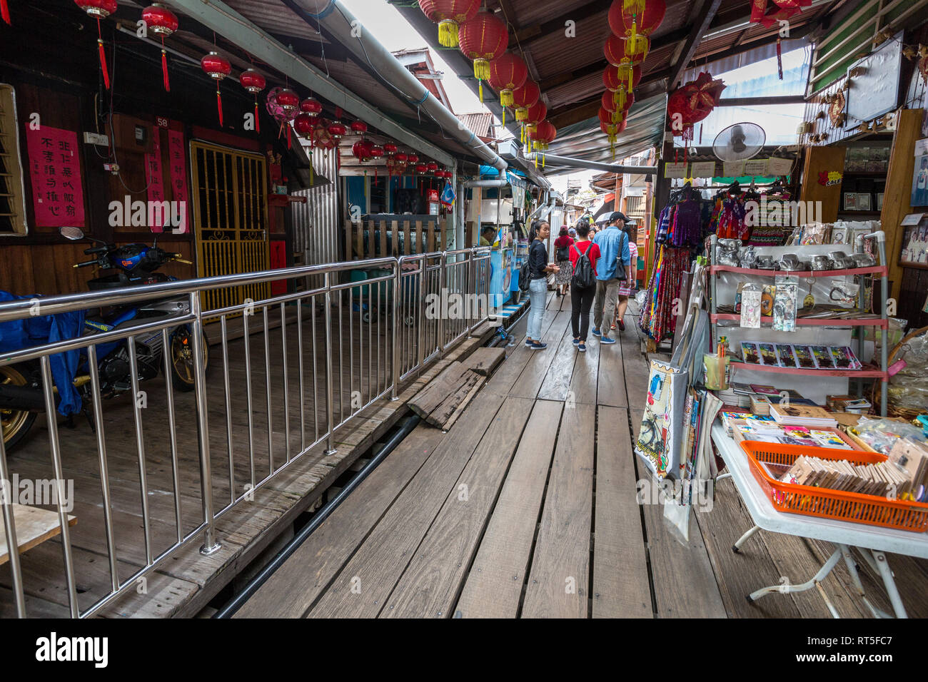 George Town, Penang, Malaysia. I visitatori a piedi passato Souvenir sorge a masticare Jetty, uno storico insediamento cinese. Foto Stock