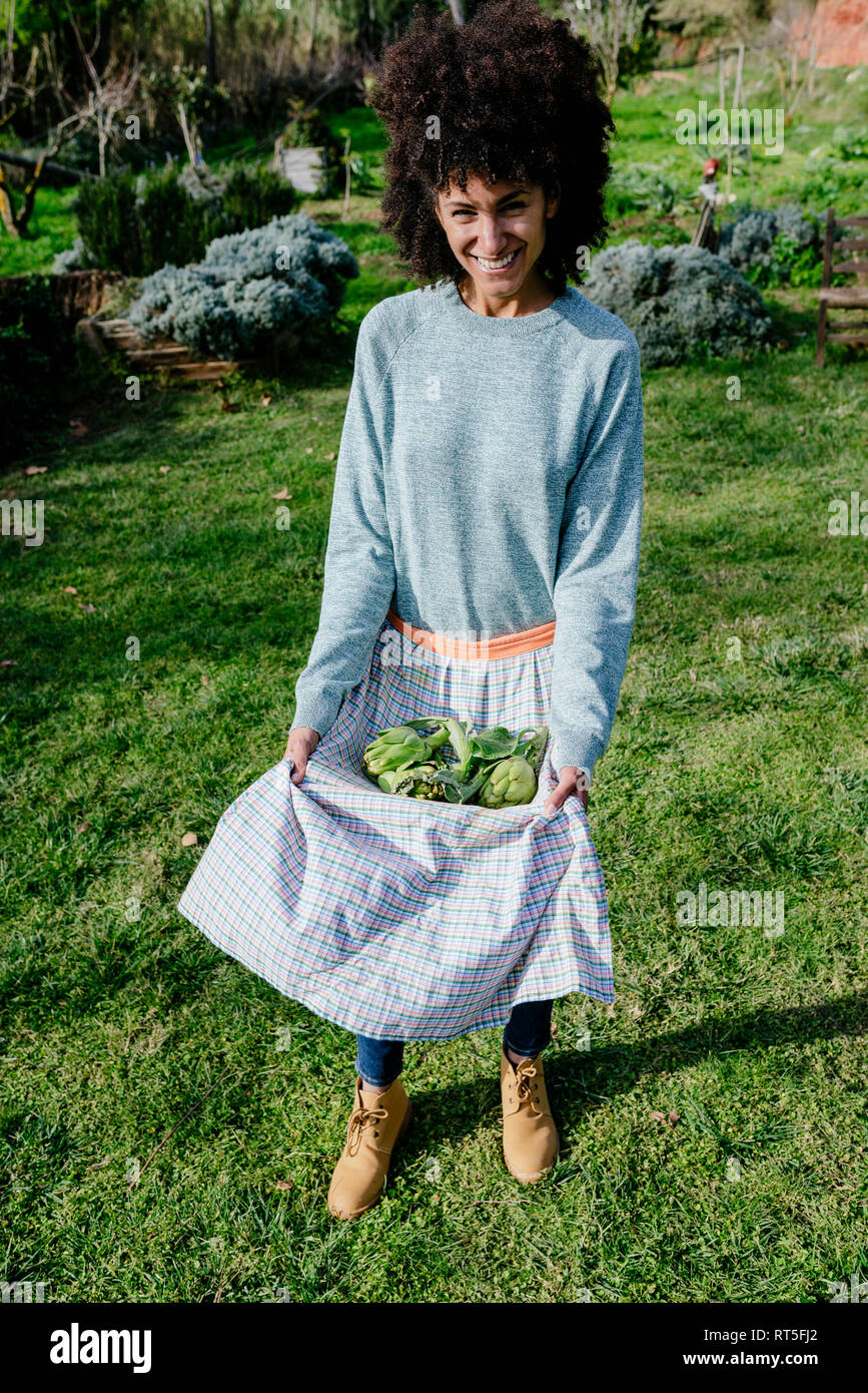 Donna che la porta appena raccolto nel suo grembiule Foto Stock