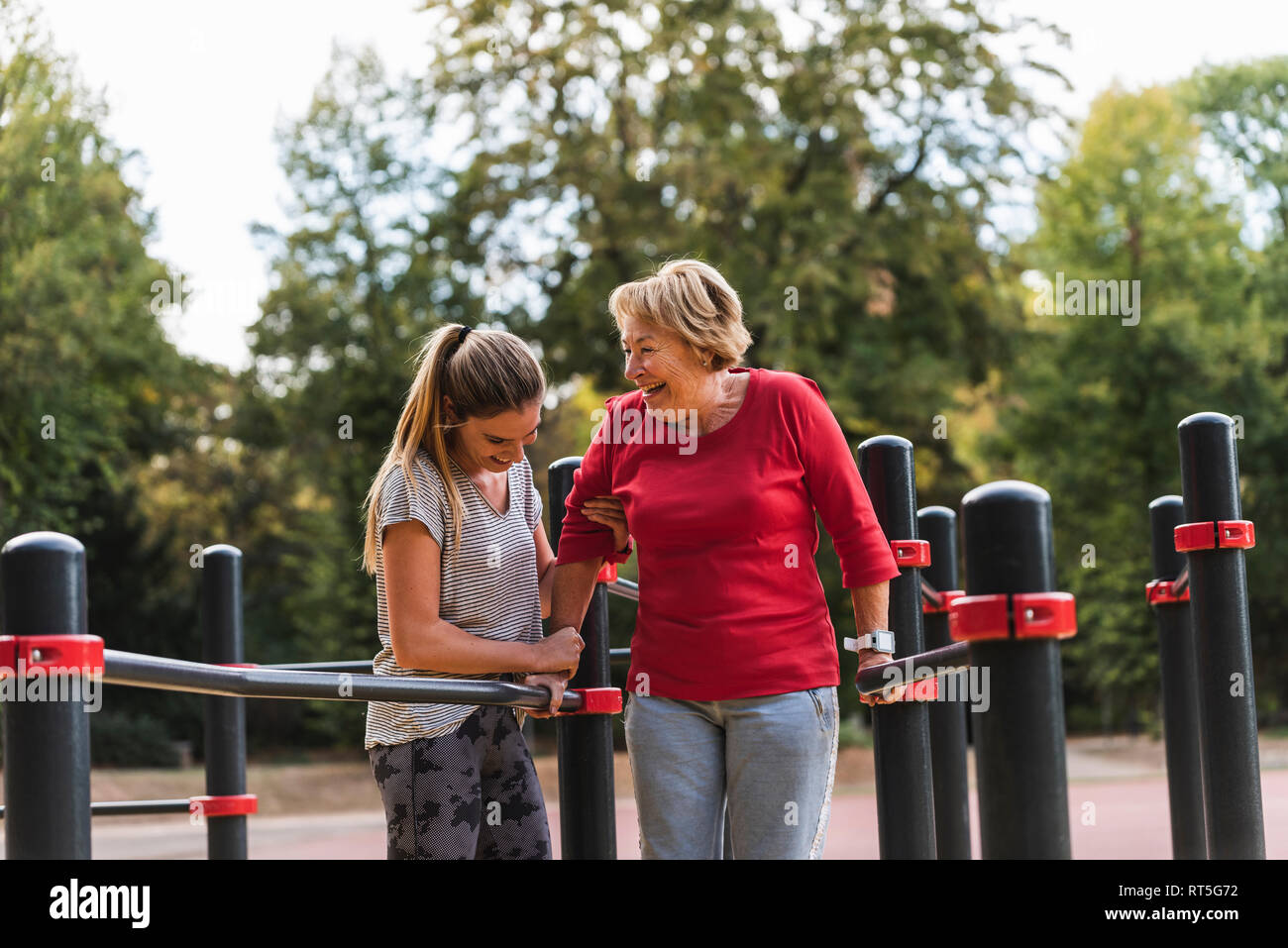 Nonna e nipote training su barre in un parco Foto Stock