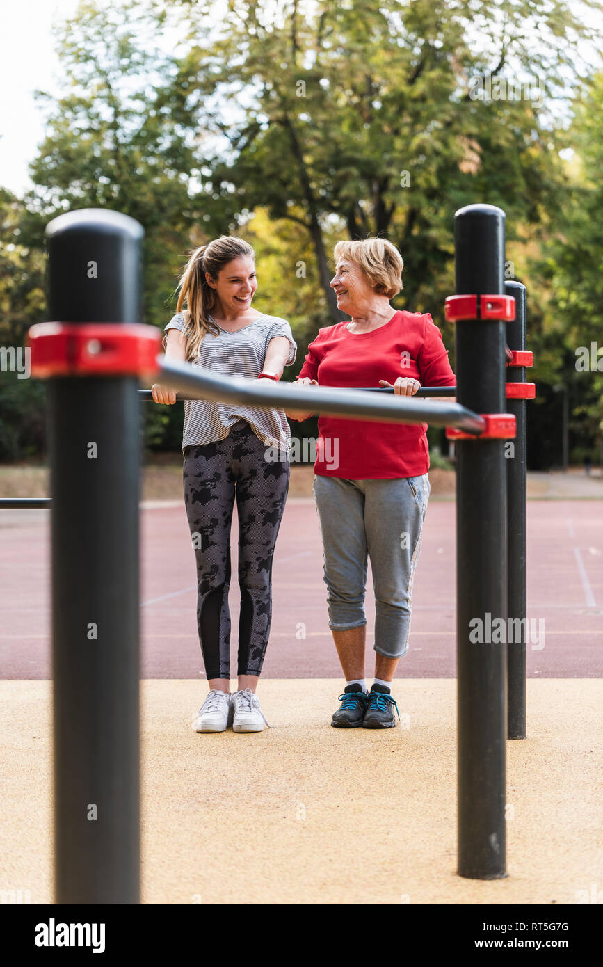Nonna e nipote training su barre in un parco Foto Stock