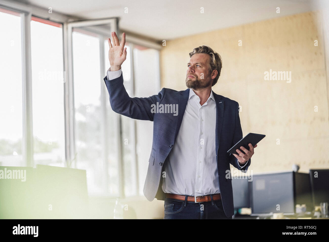 Imprenditore in piedi in ufficio, azienda talet digitale, utilizzando la sua fantasia Foto Stock