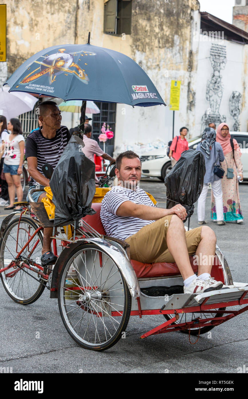 George Town, Penang, Malaysia. In Trishaw con passeggero. Foto Stock
