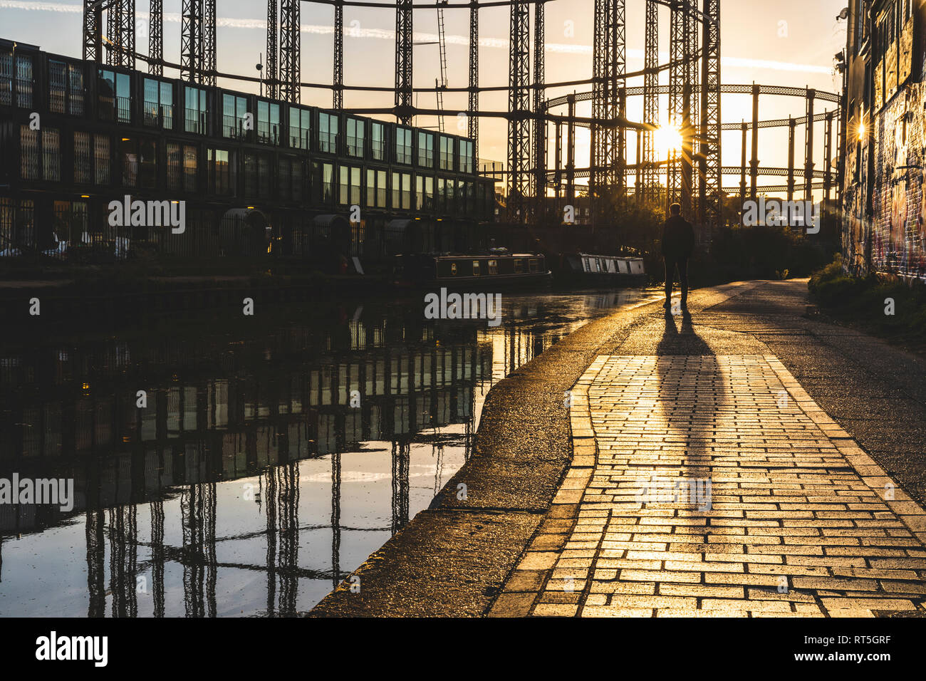Regno Unito, Inghilterra, Londra, uomo in piedi al Regent's Canal contro il sole di sera Foto Stock