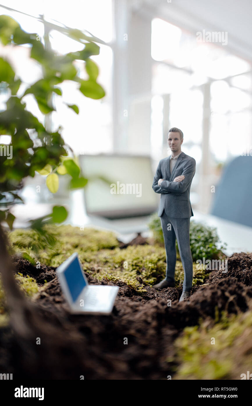 Imprenditore figurina con il computer portatile in piedi sul verde muschio Foto Stock