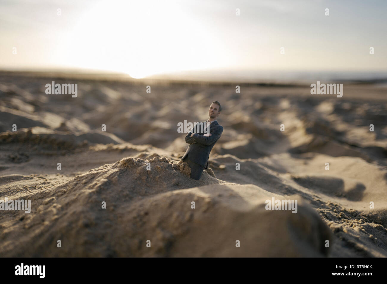 Imprenditore figurina bloccati nella sabbia Foto Stock