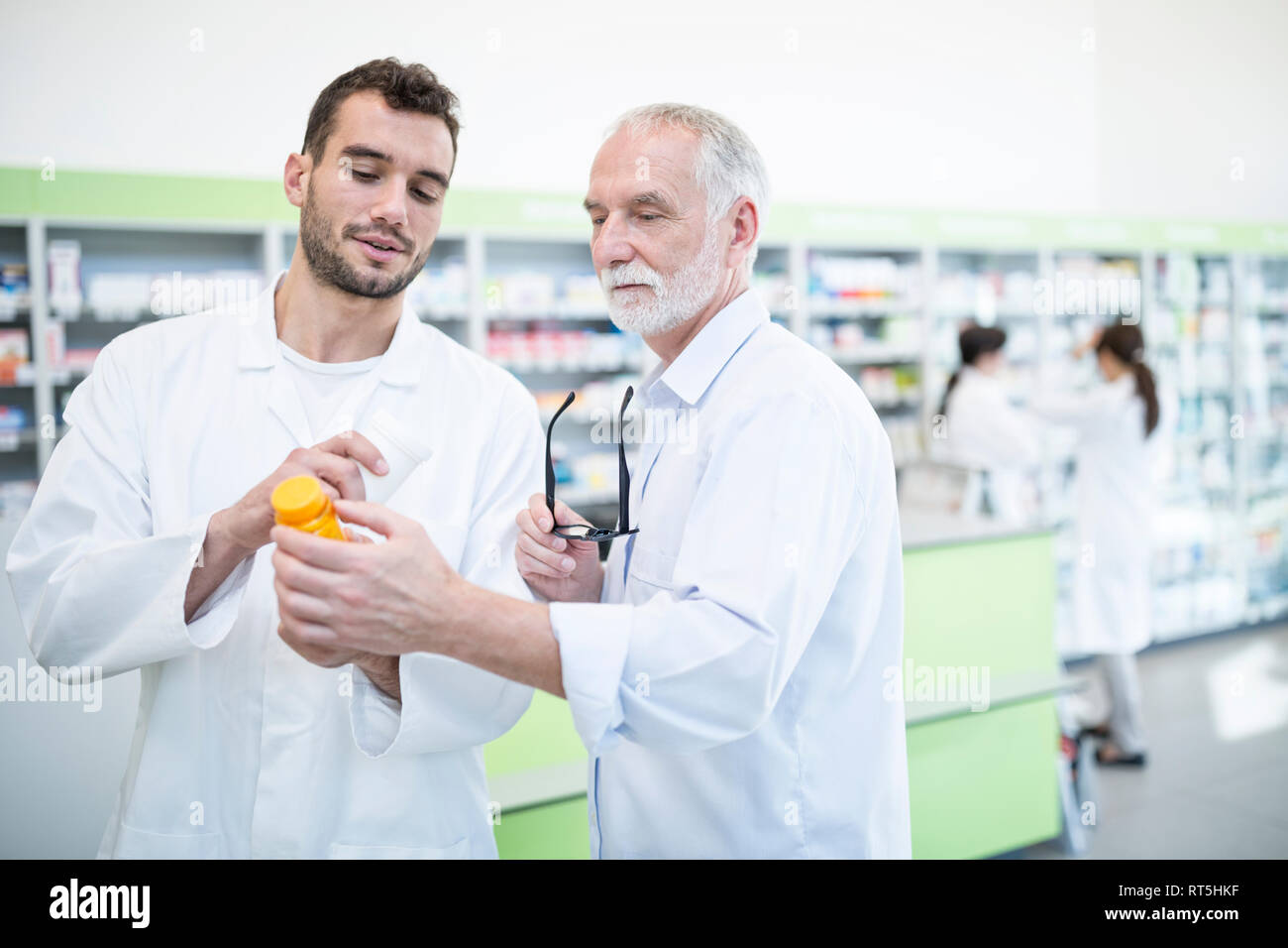 Due farmacisti esame di medicine in farmacia Foto Stock