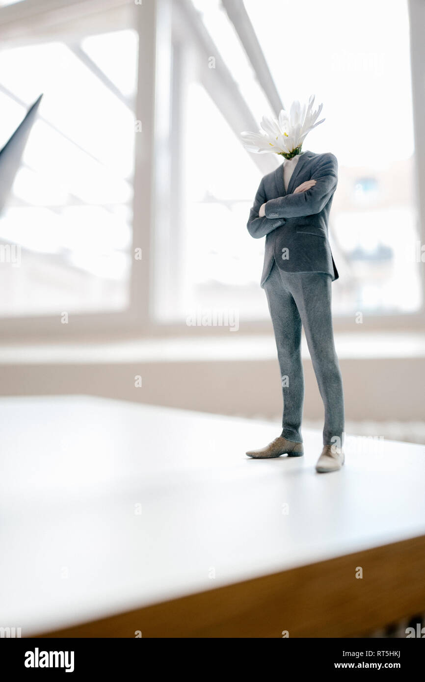 Imprenditore figurine con una testa di fiori in piedi sulla scrivania Foto Stock