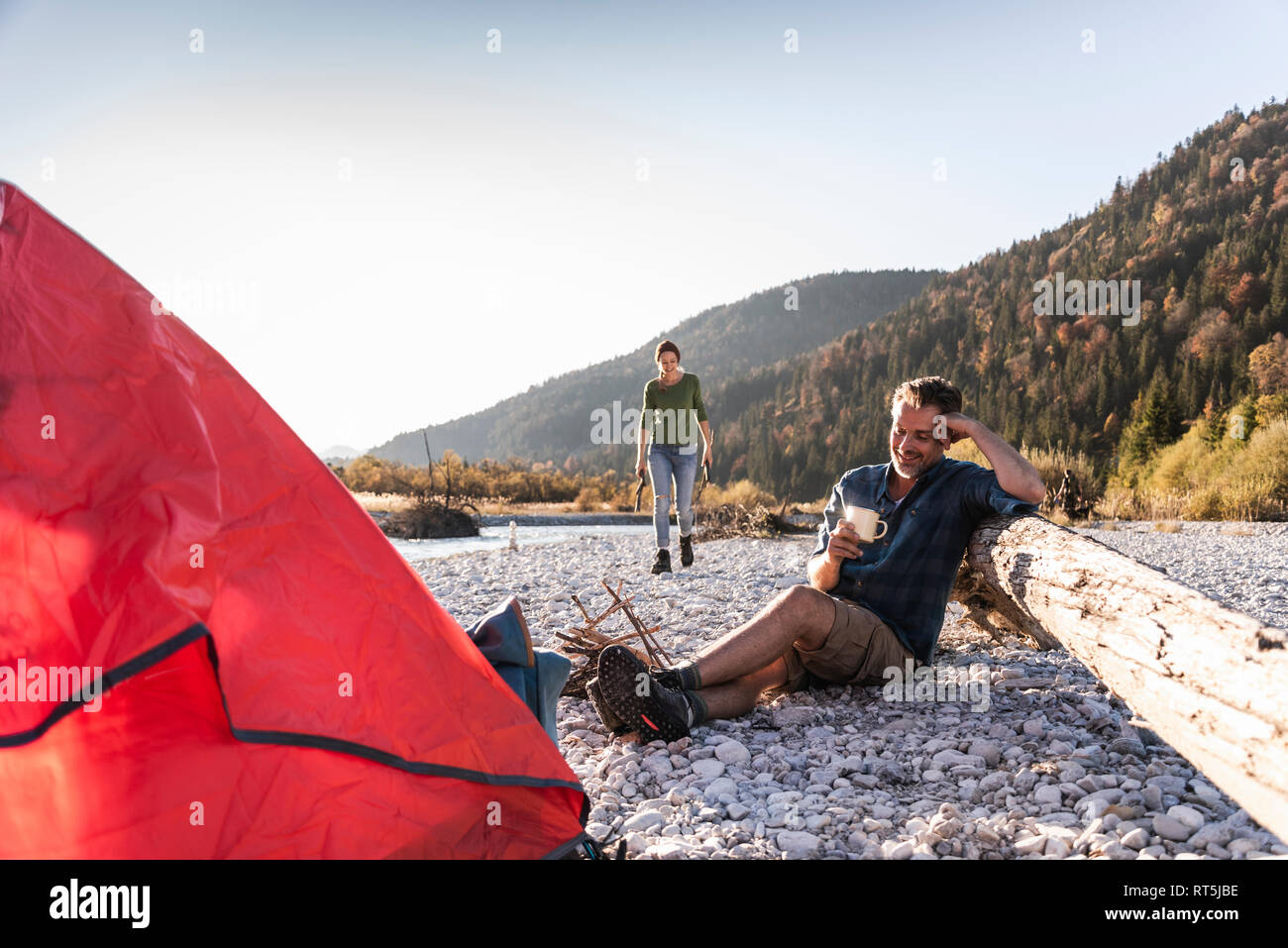 Coppia matura campeggio al Riverside nella luce della sera Foto Stock