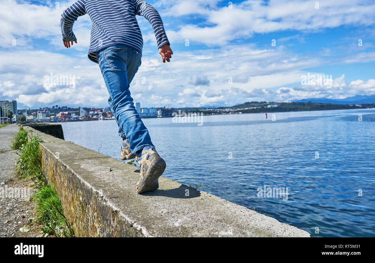 Il Cile, Puerto Montt boy in esecuzione sul quay parete presso il porto Foto Stock