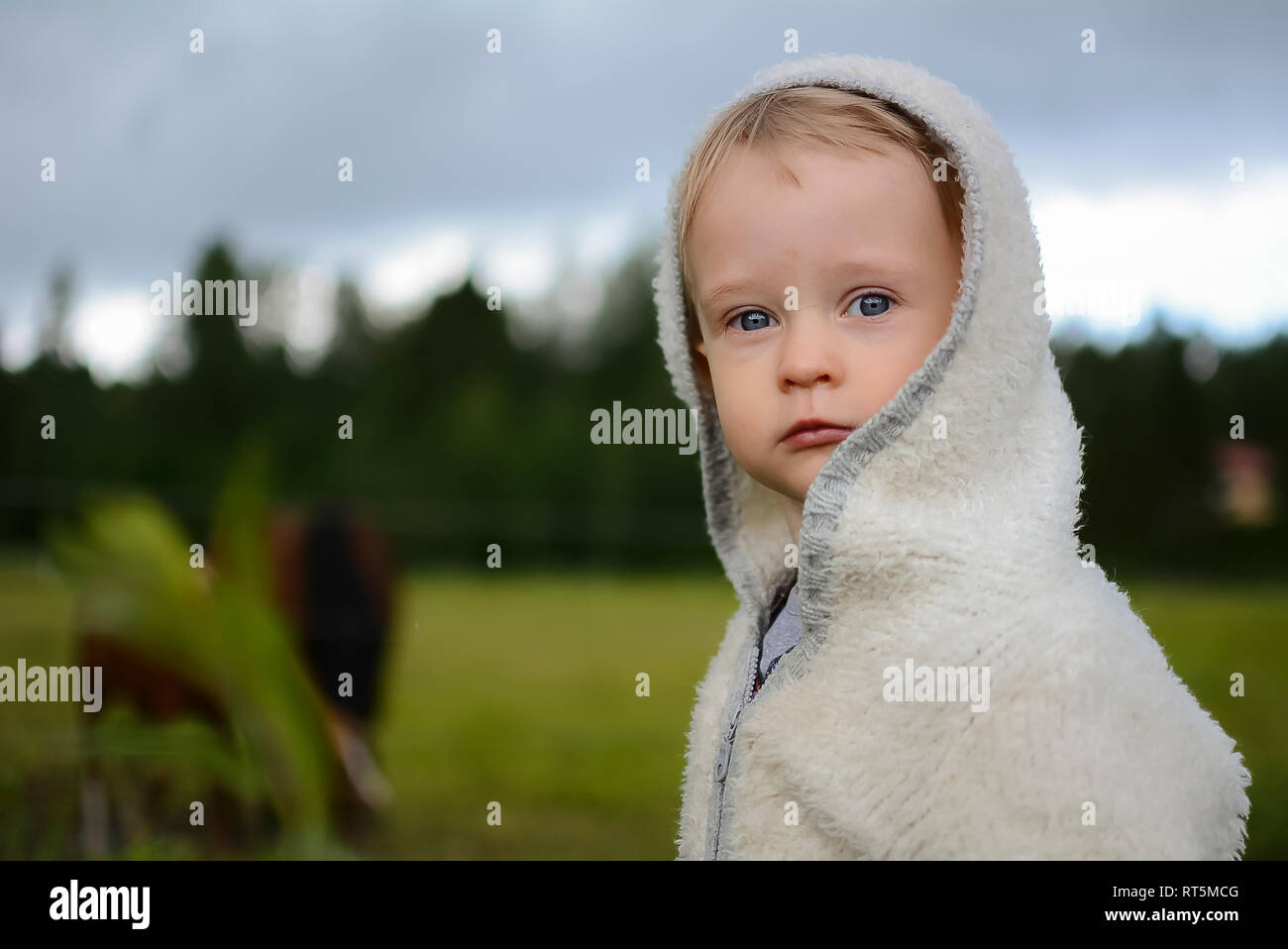 Ritratto di grave bambina indossando giacca con cappuccio Foto Stock