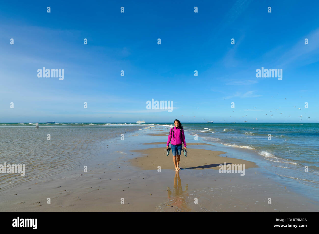 Danimarca, nello Jutland, Skagen, Grenen, donna sulla capezzagna con il Mare del Nord e del Mar Baltico Foto Stock