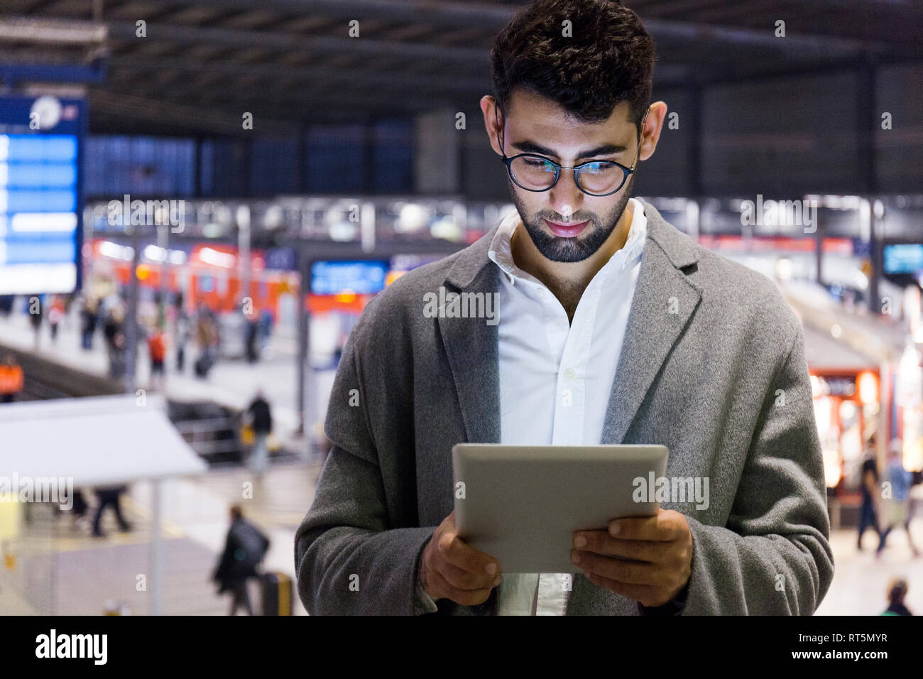 Germania - Monaco, giovane impreditore con tavoletta digitale presso la stazione centrale Foto Stock