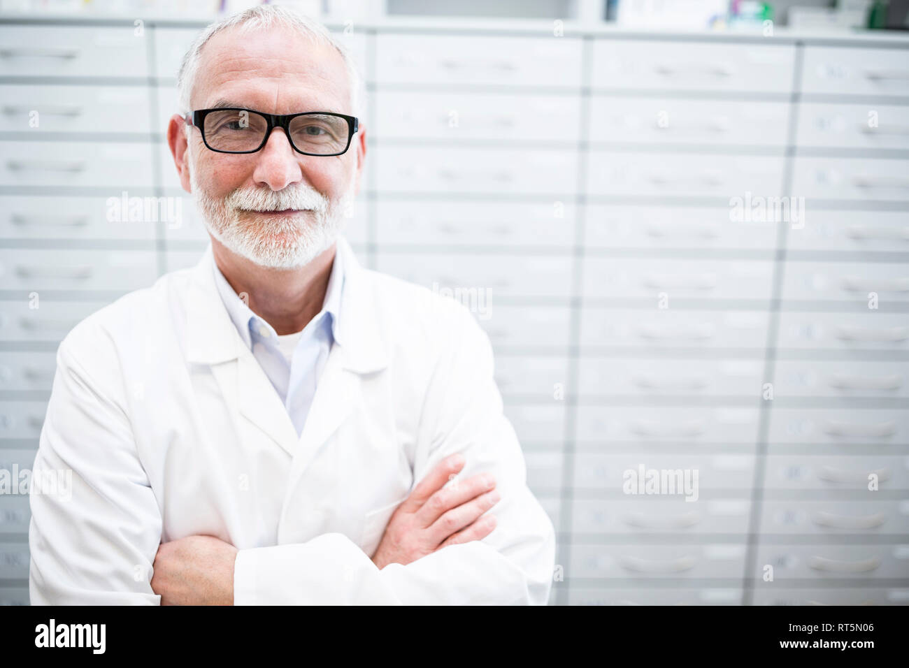 Ritratto di sorridere il farmacista a armadio in farmacia Foto Stock