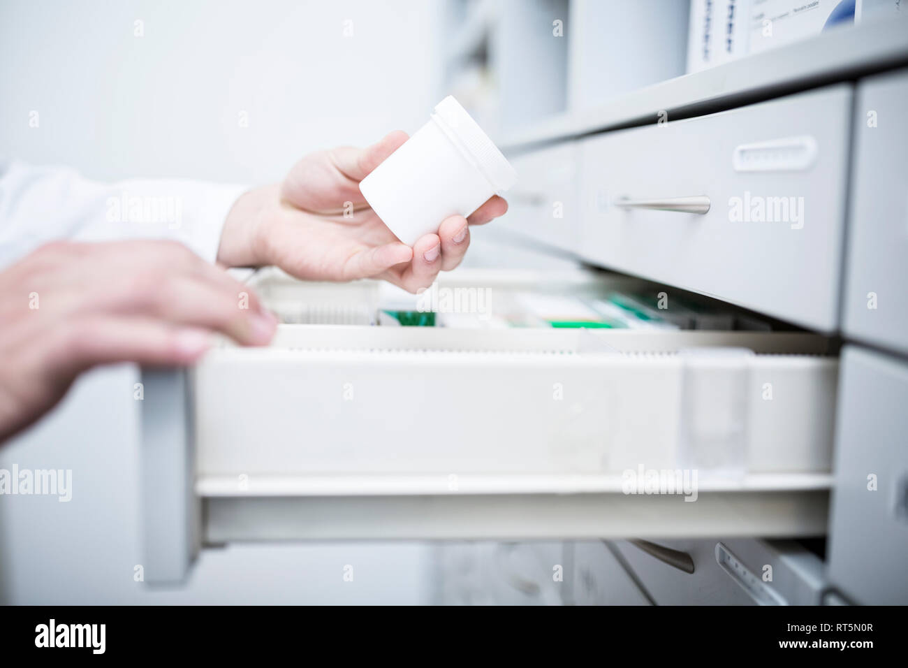 Close-up di il farmacista di prendere la medicina dal cabinet in farmacia Foto Stock
