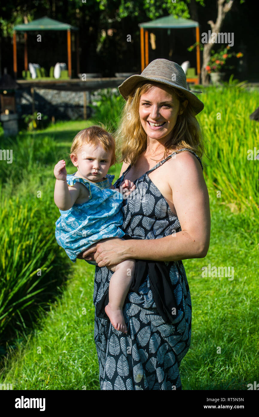 Indonesia Bali Ubud, Donna con la sua bambina in risaie. Foto Stock