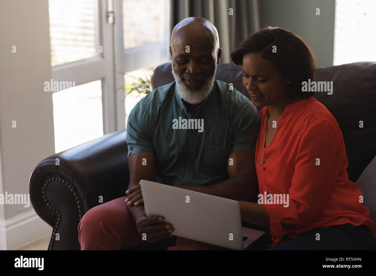 Coppia senior con tavoletta digitale nel salotto di casa Foto Stock