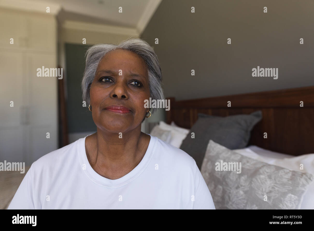 Senior donna rilassante in camera da letto a casa Foto Stock