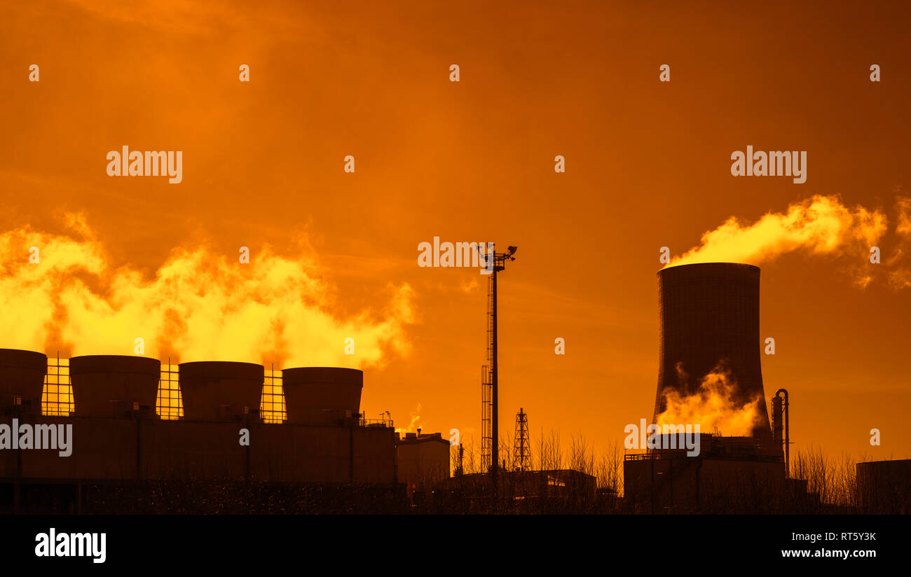 Industrial Estate al tramonto che mostra la torre di raffreddamento e camini presso la BASF produzione chimica sito nel porto di Anversa, Belgio Foto Stock