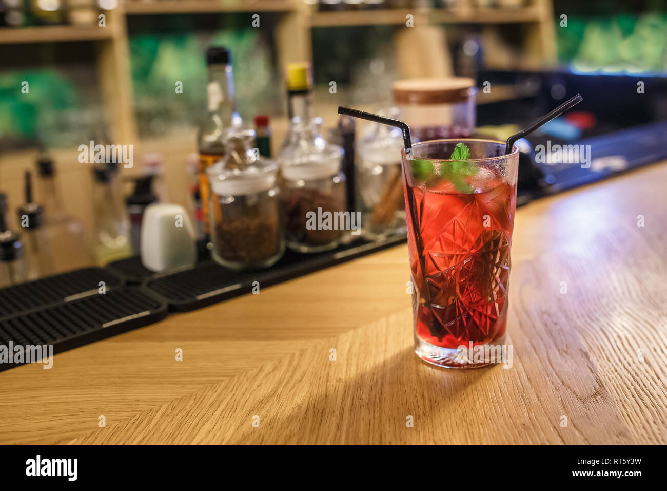 Pronto rosso cocktail alcolici su barre di sfondo di spezie in un bar di elite per la realizzazione di un cocktail di cannella spicchio di rosa canina ubriaco Cherry Foto Stock