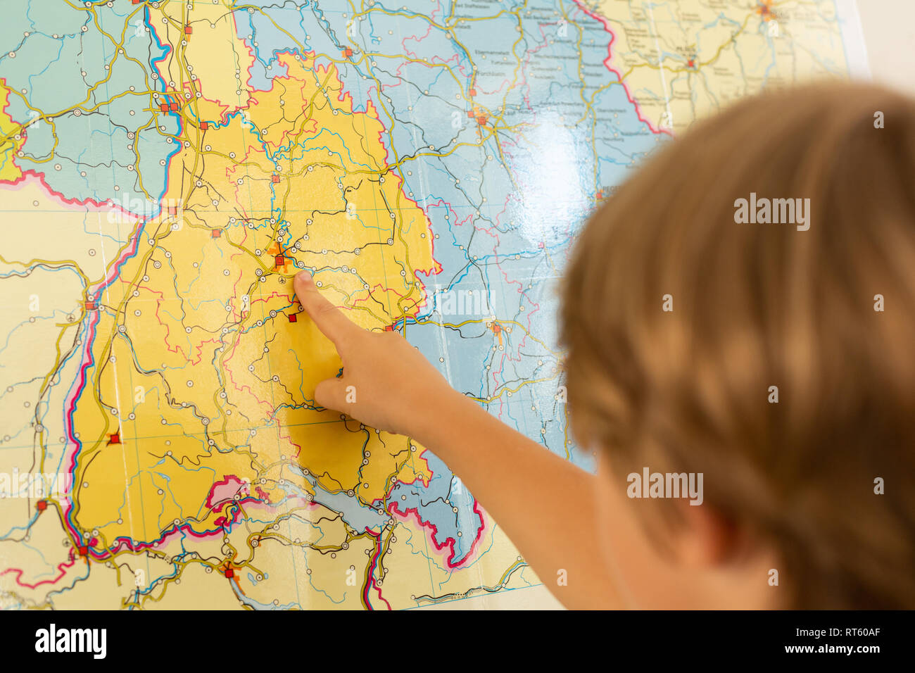 Ragazzo puntando il dito sulla mappa del mondo in una classe Foto Stock