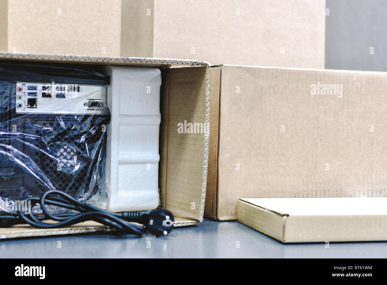 Disimballaggio black personal computer, vista posteriore, cellophane imballaggio. Molte scatole per desktop componenti hardware. Foto Stock