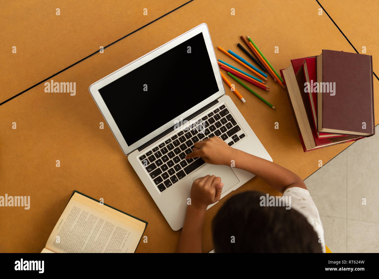 Scolaro utilizzando laptop a tavola in una classe Foto Stock