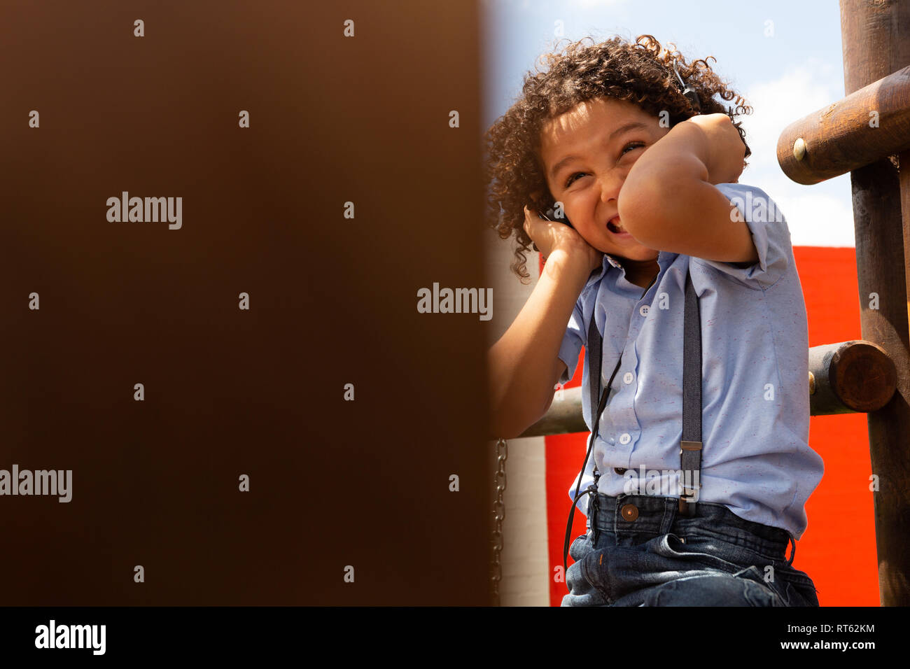 Schoolgirl ascoltando musica sulle cuffie nella scuola parco giochi Foto Stock