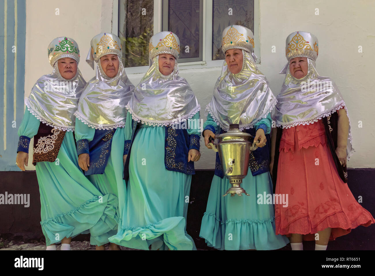 Villaggio kazako nonne holding samovar in una giornata ventosa, Sharafkent, Kazakistan Foto Stock