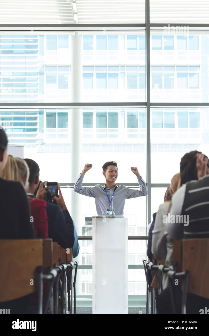 Giovane imprenditore asiatico il tifo durante il seminario Foto Stock