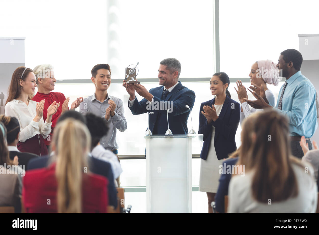 Imprenditore azienda award al podio con i colleghi in un seminario di business Foto Stock