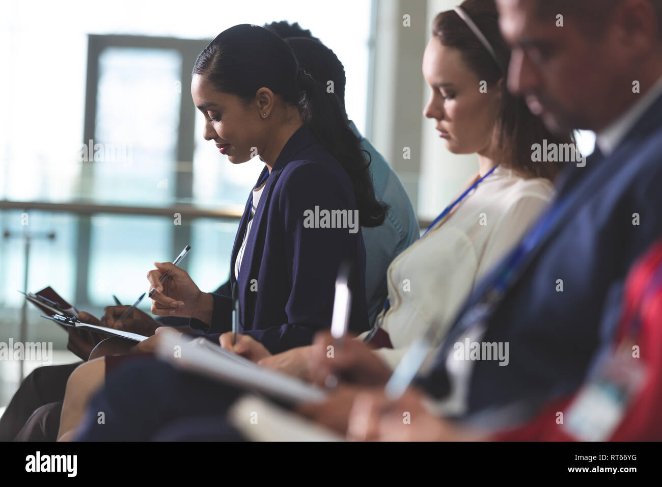 La gente di affari la scrittura sul blocco note in un seminario di business Foto Stock