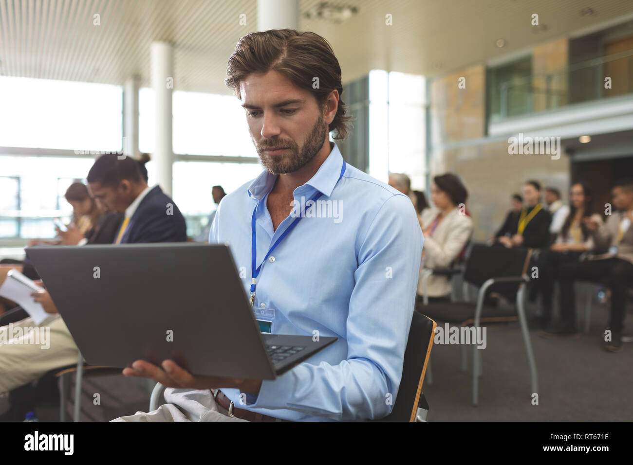 Giovane uomo d affari con computer portatile durante il seminario Foto Stock